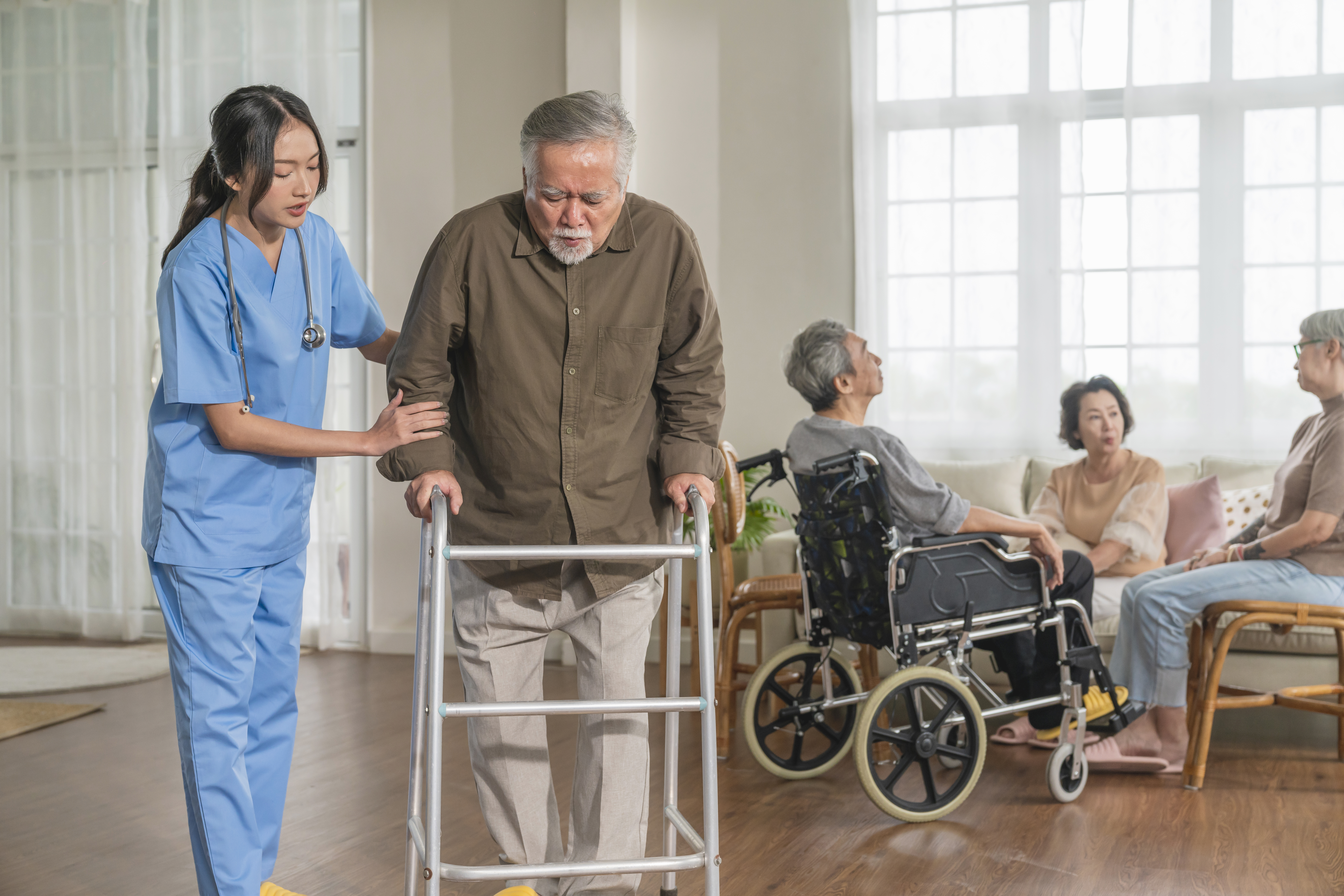 Nurse assisting senior with mobility walker